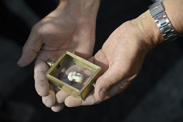 Amatrice's priest Father Savino, holds a santon of the "Madonna of Filetta" found in the ruins of the Sant'Agostino church on 30 August, 2016 in Amatrice. ANDREAS SOLARO/AFP/Getty Images