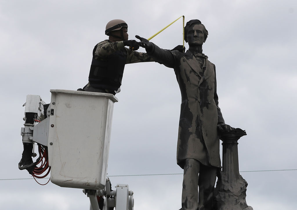 A New Orleans city worker wears body armour and a face covering as he measures the Jefferson Davis monument on 4 May, 2017, in New Orleans, Loiusiana. Photo: Justin Sullivan/Getty Images