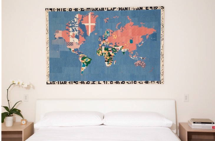 Lasciare il certo per l'incerto e viceversa (1983) by Alighiero Boetti hangs on a bedroom wall