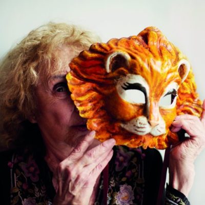 Carolee Schneemann holding a Venetian lion mask, photographed in London in May 2017, Photo: Benjamin McMahon