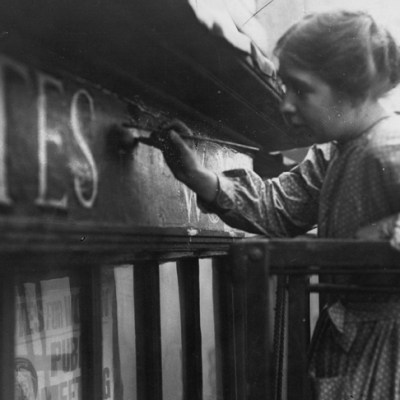 Sylvia Pankhurst painting onto the façade of the Women's Social Defence League shop in Bow Street, London (11 October 1912).