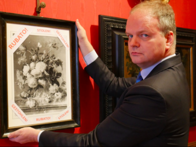 Uffizi director Eike Schmidt with a framed photograph of 'Vase of Flowers' and the word 'stolen' in Italian, English and German. Photo: @UffiziGalleries via Twitter