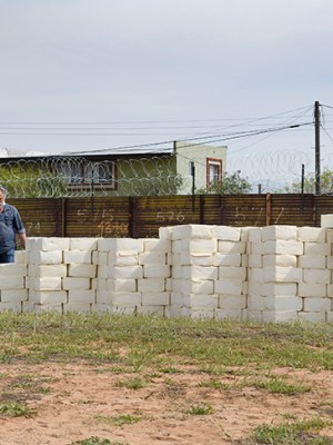 Artist Cosimo Cavallaro building his wall of cheese.