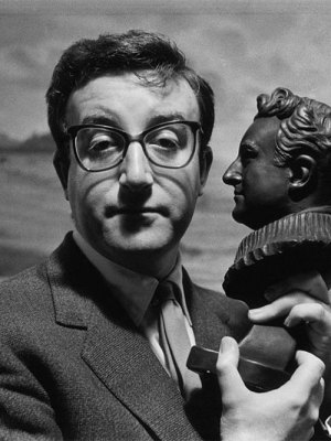 Peter Sellers holding a bust of himself.