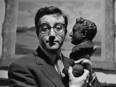 Peter Sellers holding a bust of himself.