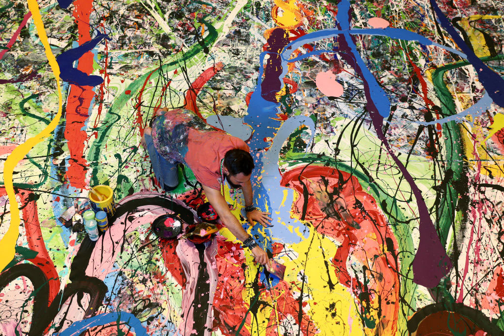 Art attack: Sacha Jafri painting his record- (and potentially back-) breaking artwork.