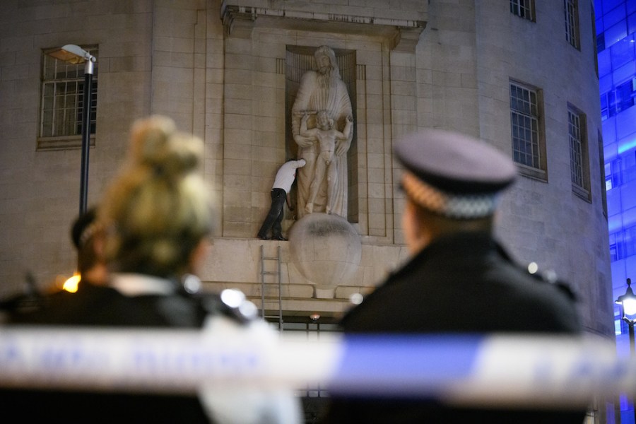 Up to the Gill – an activist with a hammer scales the BBC’s Broadcasting House. Photo: Leon Neal/Getty Images