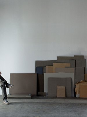 portrait of a man sitting on a chair in a warehouse space